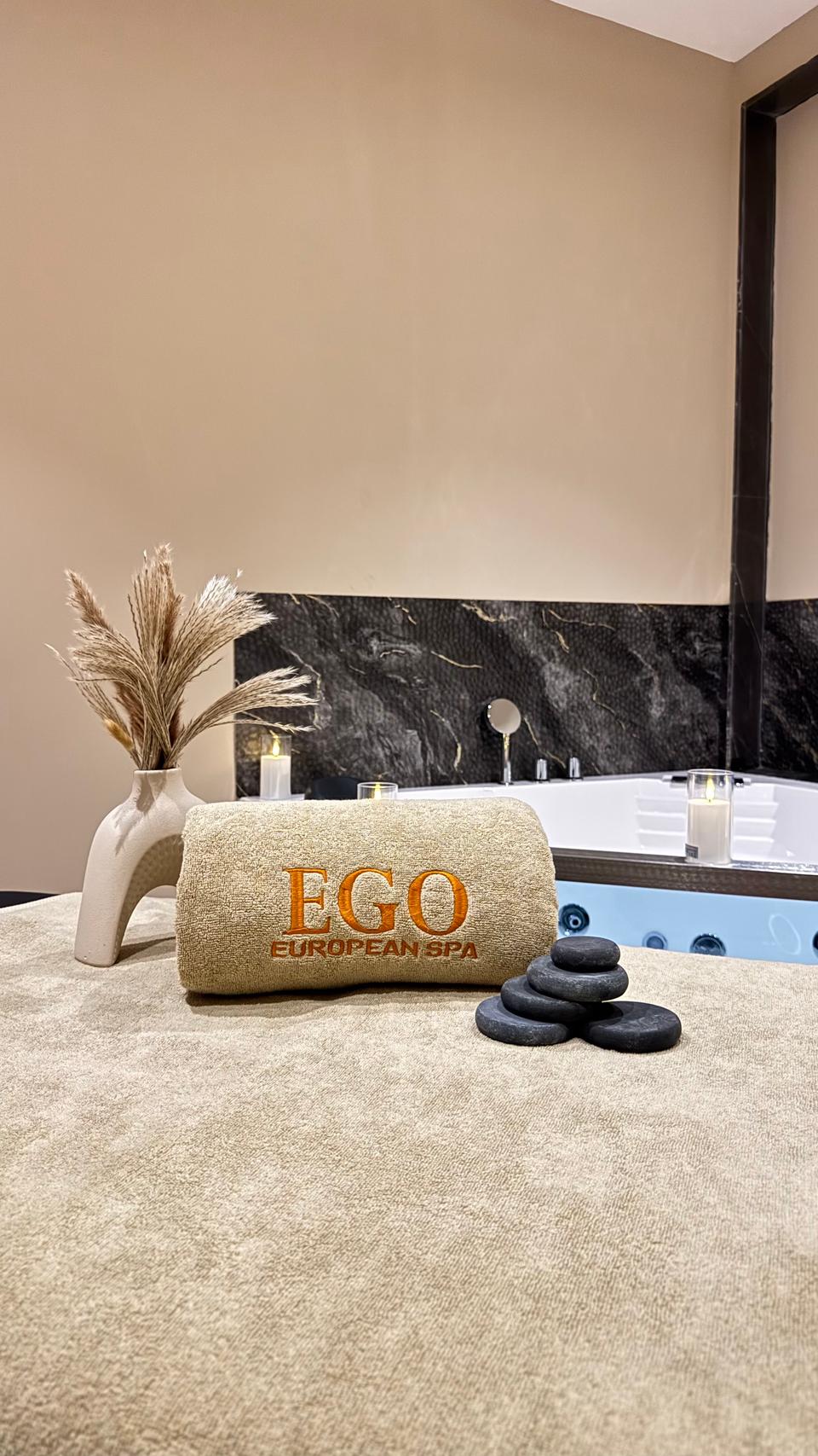 Treatment room at Ego European Spa Dubai with EGO branded towel, hot stones, and jacuzzi at Jannah Dubai Creek Hotel Deira
