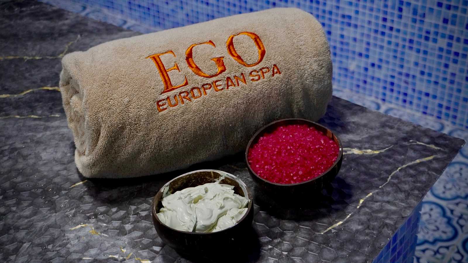 Jacuzzi massage in Deira, Dubai — rolled EGO towel and bowls of bath salt and body cream at the mosaic jacuzzi